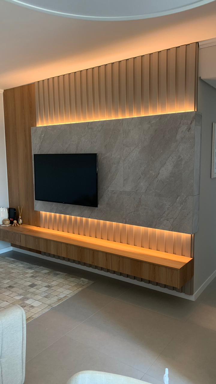 Painel de lareira em mármore branco Paraná com rasgos de iluminação embutida.